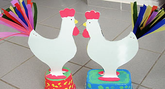 Easter roosters standing on painted pots.